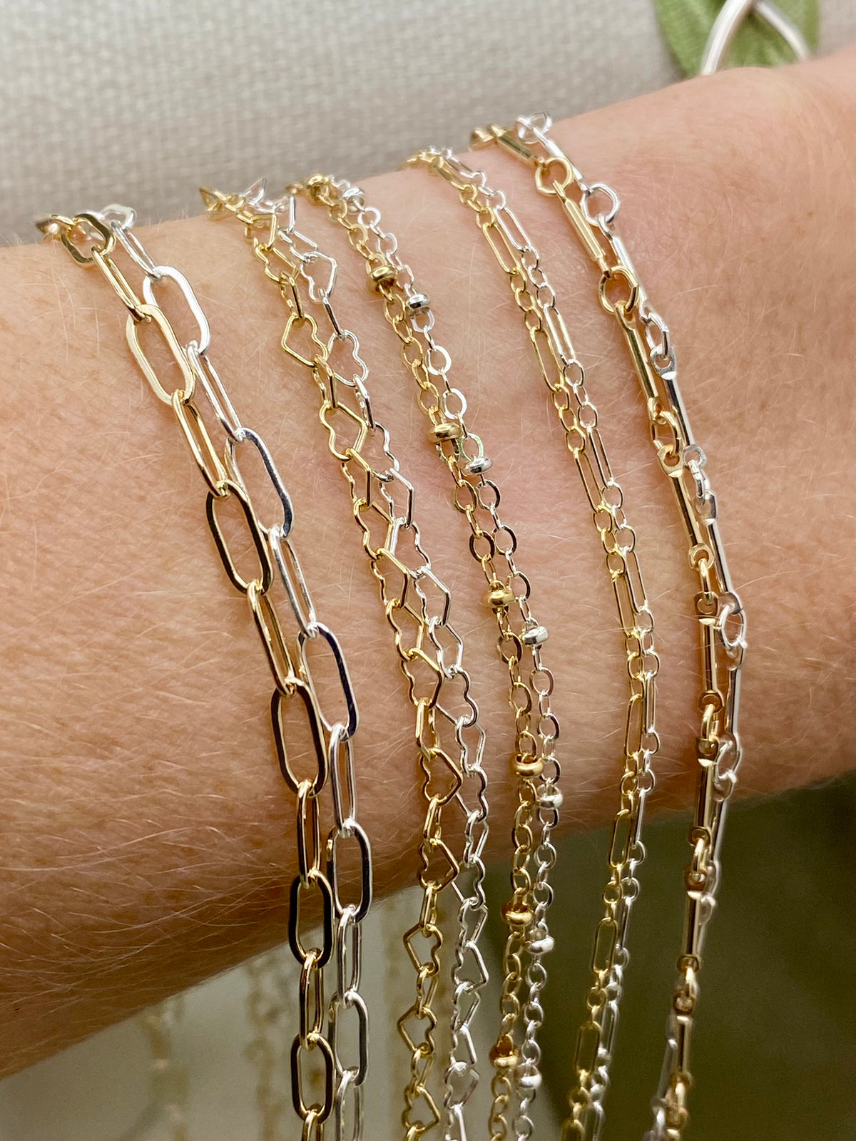 Gold filled permanent jewelry chain bracelets layered on wrist