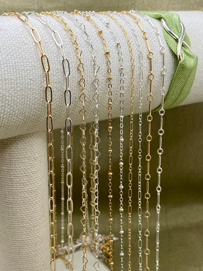 Gold filled and sterling silver chain spools displayed together close up