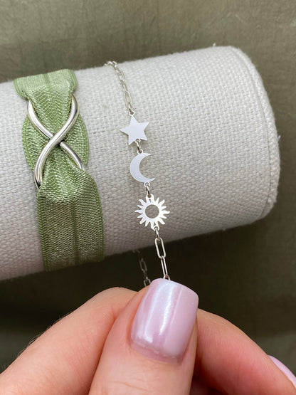 Silver star connector joined with crescent moon and sun connectors in a celestial bracelet on a display