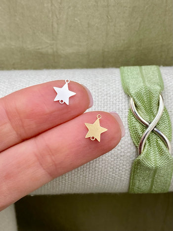 Star connectors in sterling silver and gold-filled finishes with two attachment loops, shown on fingertips