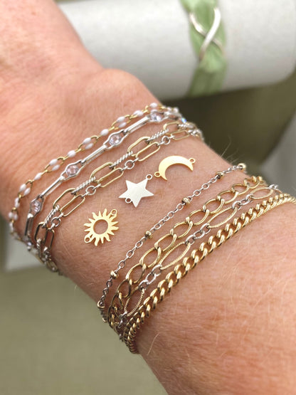 Silver star connector shown with sun and crescent moon connectors beside layered bracelets