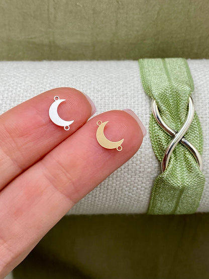 Sterling silver and gold-filled crescent moon connectors with two attachment loops displayed on fingertips
