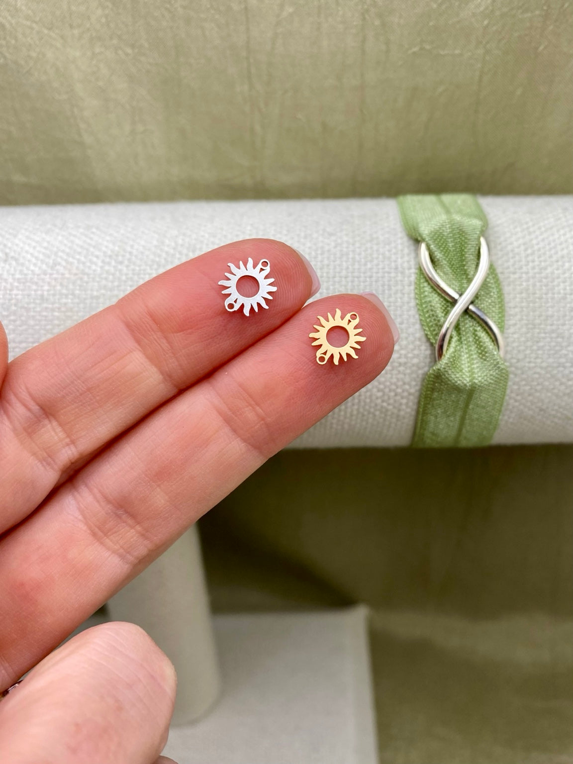 Silver and gold-filled sun connectors with two attachment loops shown on fingertips