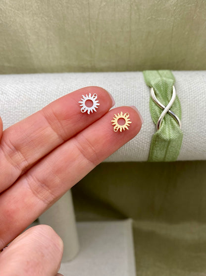 Silver and gold-filled sun connectors with two attachment loops shown on fingertips
